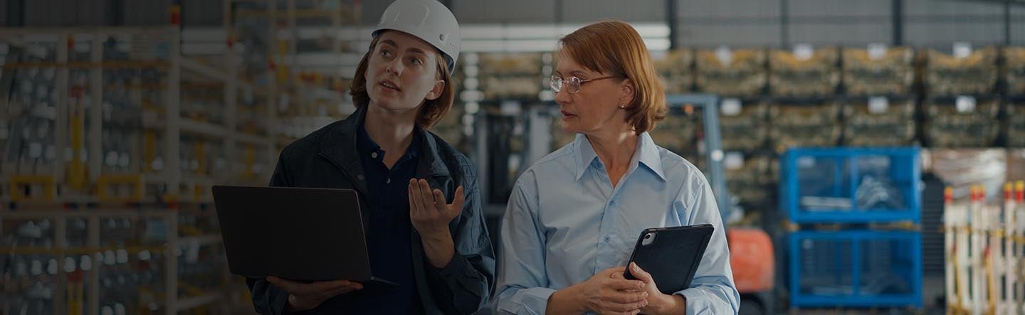 two persons having a conversation in a warehouse